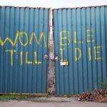 Gates at Plough Lane with the graffiti "Womble Till I Die"